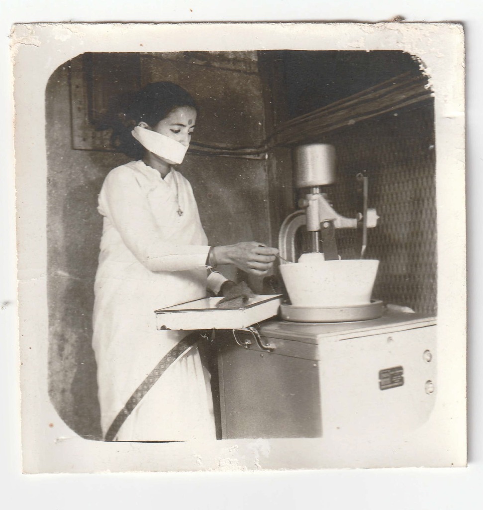 A member of staff operating a compounding machine inside Shree Krishna Aushadhalaya. Date unrecorded.