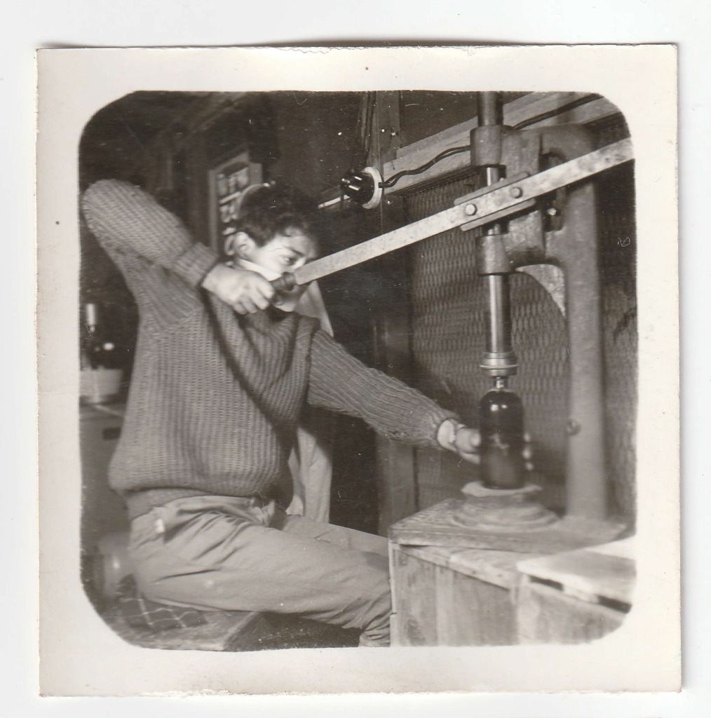A member of staff operating a heavy mechanical press inside the Shree Krishna Aushadhalaya manufacturing environment. Date unrecorded.