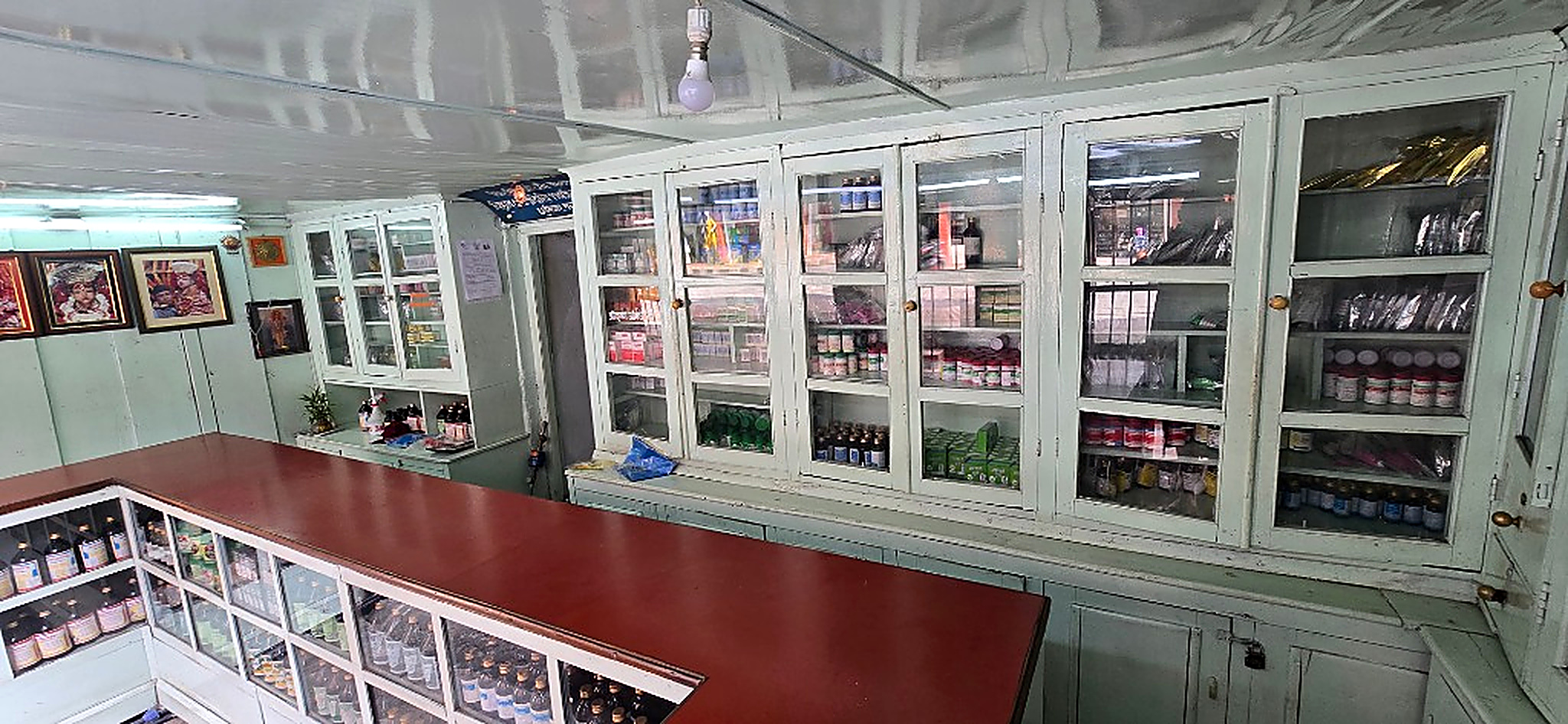 Interior of Shree Krishna Aushadhalaya traditional dispensary counter in Bagbazar showing wooden shelving and amber apothecary bottles