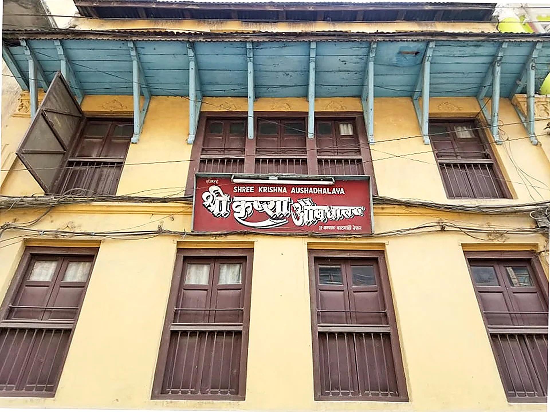 Building facade showing authentic wooden eaves and Shree Krishna Aushadhalaya premises in Bagbazar