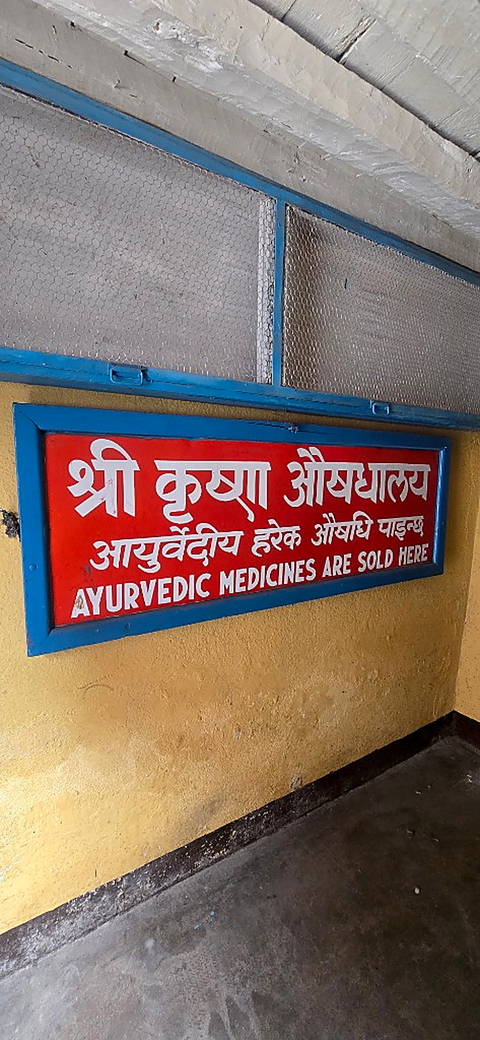 Interior wooden sign announcing traditional Ayurvedic medicines
